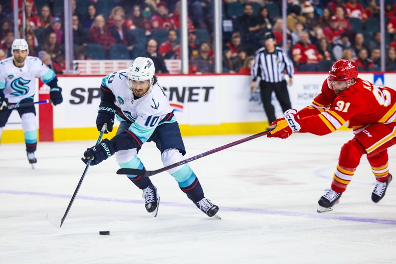 Mar 4, 2024; Calgary, Alberta, CAN; Seattle Kraken center Matty Beniers (10) and Calgary Flames center Nazem Kadri (91) battles for the puck during the first period at Scotiabank Saddledome. Mandatory Credit: Sergei Belski-USA TODAY Sports