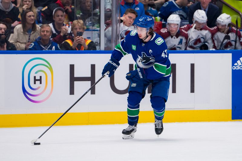 Mar 13, 2024; Vancouver, British Columbia, CAN; Vancouver Canucks defenseman Quinn Hughes (43) handles the puck against the Colorado Avalanche in the third period at Rogers Arena. Colorado won 4 -3 in overtime. Mandatory Credit: Bob Frid-USA TODAY Sports