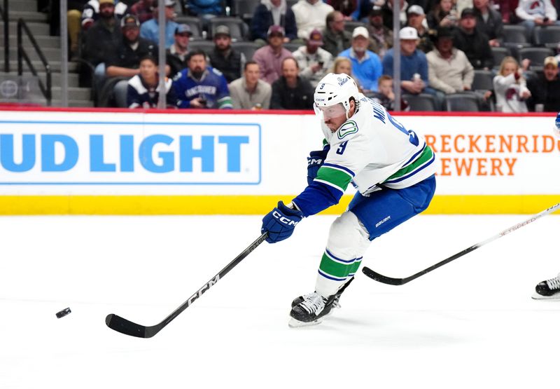 Feb 20, 2024; Denver, Colorado, USA; Vancouver Canucks center J.T. Miller (9) shoots and scores a goal in the first period against the Colorado Avalanche at Ball Arena. Mandatory Credit: Ron Chenoy-USA TODAY Sports