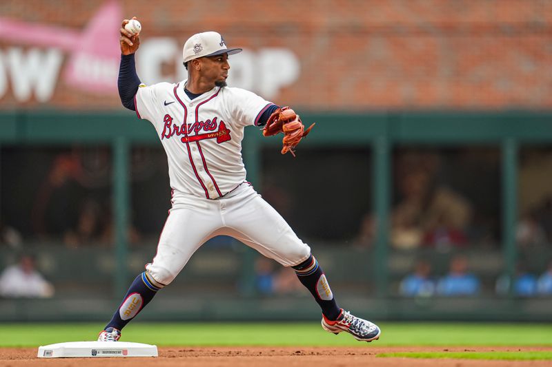 Jul 4, 2024; Cumberland, Georgia, USA; Atlanta Braves second baseman Ozzie Albies (1) turns a double play against the San Francisco Giants during the first inning at Truist Park. Mandatory Credit: Dale Zanine-USA TODAY Sports