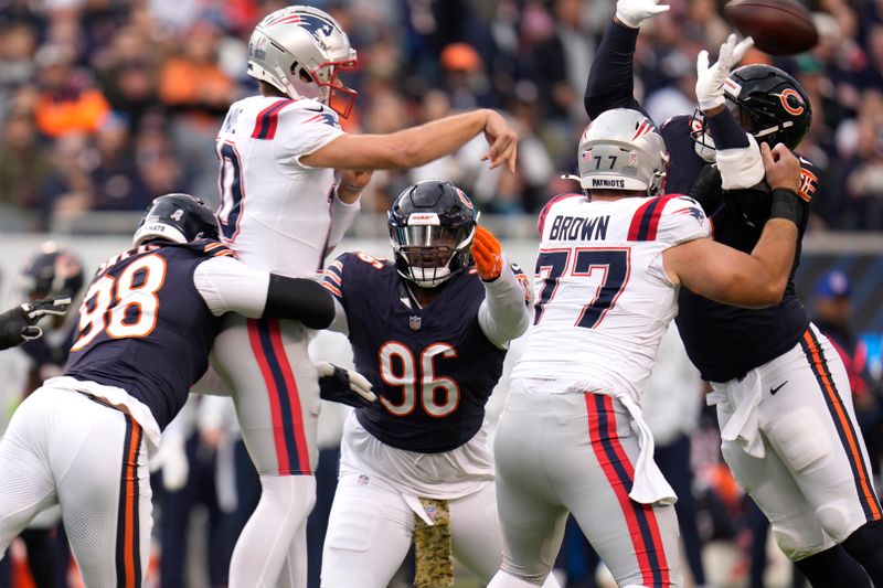 New England Patriots quarterback Drake Maye is pressured on his pass by Chicago Bears defensive end Montez Sweat (98) and Zacch Pickens (96) during the first half of an NFL football game Sunday, Nov. 10, 2024, in Chicago. (AP Photo/Erin Hooley)