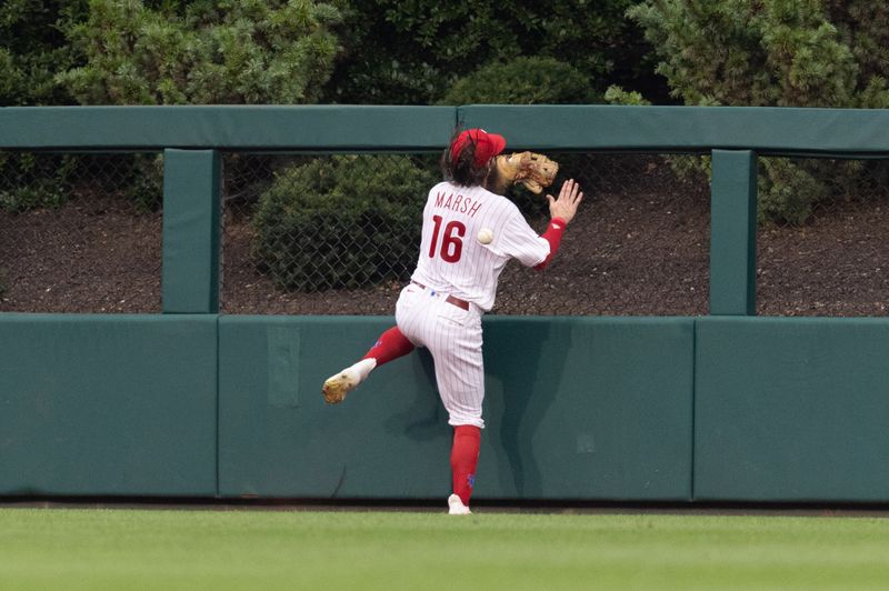 Aug 5, 2023; Philadelphia, Pennsylvania, USA; Philadelphia Phillies center fielder Brandon Marsh (16) is injured while attempting to catch the triple of Kansas City Royals second baseman Samad Taylor (not pictured) during the fifth inning at Citizens Bank Park. Mandatory Credit: Bill Streicher-USA TODAY Sports