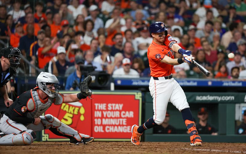 Jun 21, 2024; Houston, Texas, USA; Houston Astros shortstop Mauricio Dubon (14) hits a RBI double against the Baltimore Orioles in the sixth inning at Minute Maid Park. Mandatory Credit: Thomas Shea-USA TODAY Sports