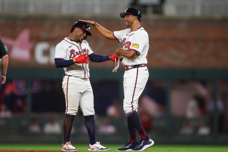 Sep 24, 2024; Atlanta, Georgia, USA; Atlanta Braves second baseman Ozzie Albies (1) celebrates with first base coach Tom Goodwin (88) after an RBI single against the New York Mets in the third inning at Truist Park. Mandatory Credit: Brett Davis-Imagn Images
