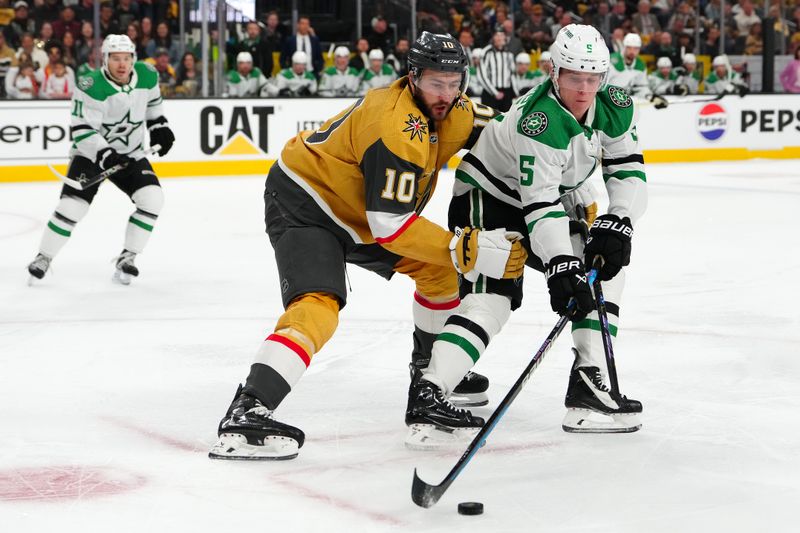 Apr 29, 2024; Las Vegas, Nevada, USA; Dallas Stars defenseman Nils Lundkvist (5) keeps the puck away from Vegas Golden Knights center Nicolas Roy (10) during the first period of game four of the first round of the 2024 Stanley Cup Playoffs at T-Mobile Arena. Mandatory Credit: Stephen R. Sylvanie-USA TODAY Sports