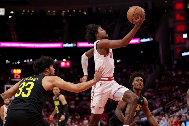 HOUSTON, TEXAS - MARCH 23: Jalen Green #4 of the Houston Rockets goes up for a shot in front of Collin Sexton #2 of the Utah Jazz and Johnny Juzang #33 in the first half at Toyota Center on March 23, 2024 in Houston, Texas.  NOTE TO USER: User expressly acknowledges and agrees that, by downloading and or using this photograph, User is consenting to the terms and conditions of the Getty Images License Agreement. (Photo by Tim Warner/Getty Images)