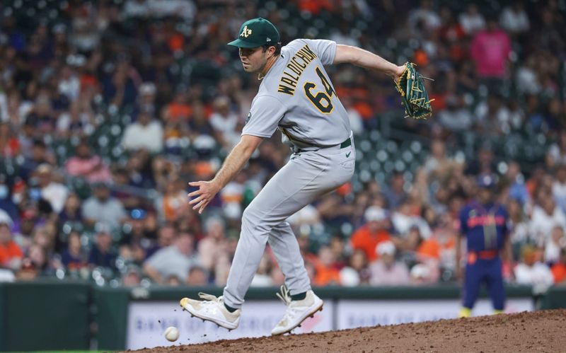 Sep 11, 2023; Houston, Texas, USA; Oakland Athletics relief pitcher Ken Waldichuk (64) attempts to field a ground ball during the eighth inning against the Houston Astros at Minute Maid Park. Mandatory Credit: Troy Taormina-USA TODAY Sports