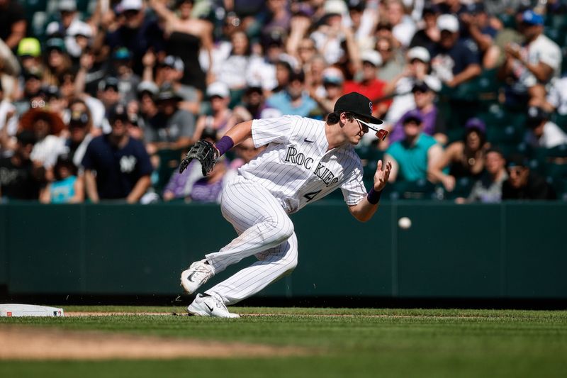 Jul 16, 2023; Denver, Colorado, USA; Colorado Rockies first baseman Michael Toglia (4) loses his glasses attempting to field a throw in the ninth inning against the New York Yankees at Coors Field. Mandatory Credit: Isaiah J. Downing-USA TODAY Sports