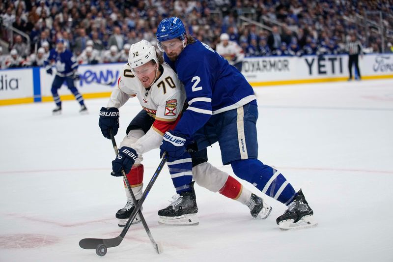 May 14, 2025; Toronto, Ontario, CAN; Florida Panthers forward Jesper Boqvist (70)  and Toronto Maple Leafs defenceman Simon Benoit (2) battle for the puck  during the second period of game five of the second round of the 2025 Stanley Cup Playoffs at Scotiabank Arena. Mandatory Credit: John E. Sokolowski-Imagn Images