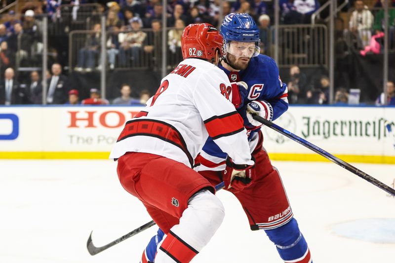 May 5, 2024; New York, New York, USA; Carolina Hurricanes center Jesperi Kotkaniemi (82) collides with New York Rangers defenseman Jacob Trouba (8) in the third period in game one of the second round of the 2024 Stanley Cup Playoffs at Madison Square Garden. Mandatory Credit: Wendell Cruz-USA TODAY Sports