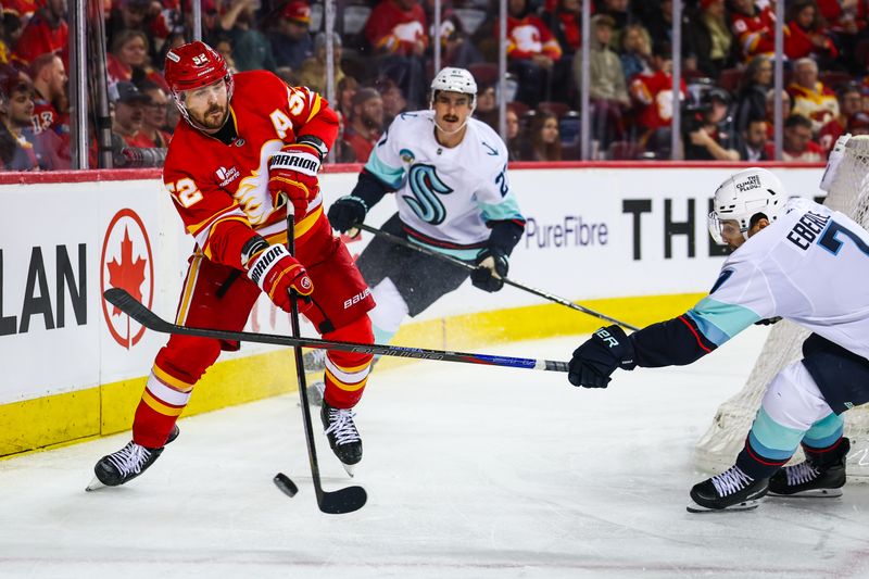 Dec 18, 2025; Calgary, Alberta, CAN; Calgary Flames defenseman Mackenzie Weegar (52) controls the puck against Seattle Kraken right wing Jordan Eberle (7) during the third period at Scotiabank Saddledome. Mandatory Credit: Sergei Belski-Imagn Images