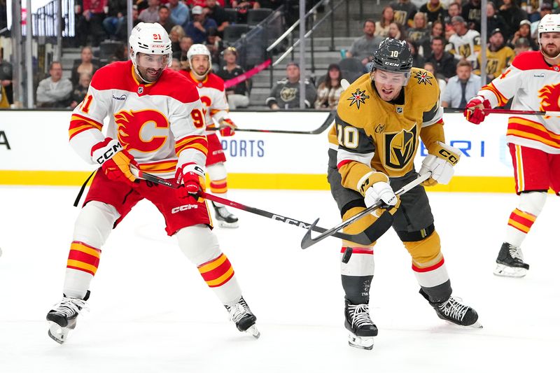 Oct 18, 2025; Las Vegas, Nevada, USA; Vegas Golden Knights center Colton Sissons (10) battles against Calgary Flames center Nazem Kadri (91) for a loose puck during the second period at T-Mobile Arena. Mandatory Credit: Stephen R. Sylvanie-Imagn Images