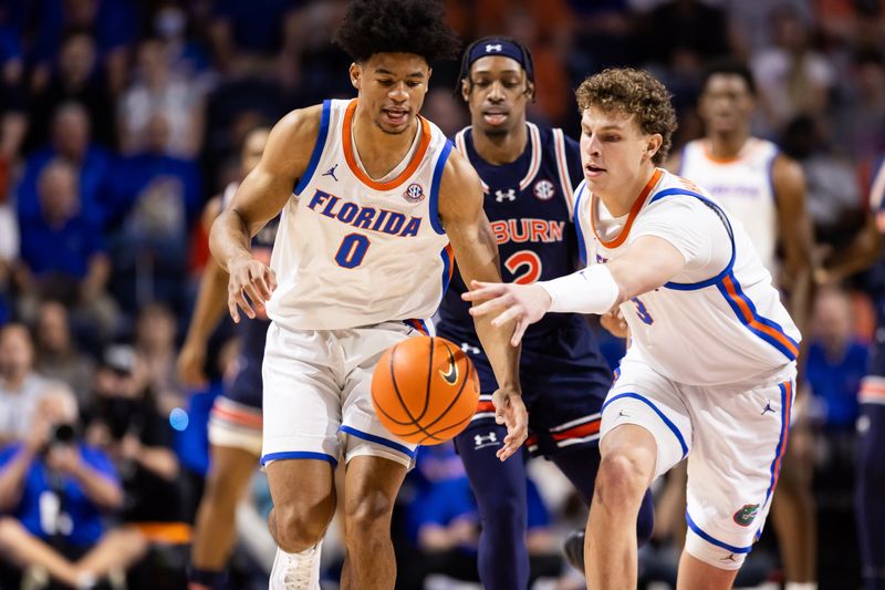 Feb 10, 2024; Gainesville, Florida, USA; Florida Gators guard Zyon Pullin (0) and center Micah Handlogten (3) battle for a loose ball against the Auburn Tigers during the first half at Exactech Arena at the Stephen C. O'Connell Center. Mandatory Credit: Matt Pendleton-USA TODAY Sports