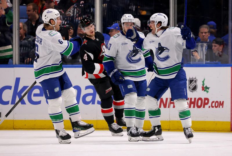 Nov 29, 2024; Buffalo, New York, USA;  Vancouver Canucks right wing Conor Garland (8) celebrates his overtime goal with teammates during the third period against the Buffalo Sabres at KeyBank Center. Mandatory Credit: Timothy T. Ludwig-Imagn Images