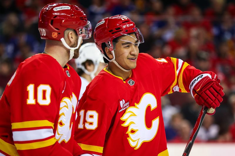 Feb 2, 2026; Calgary, Alberta, CAN; Calgary Flames defenseman Zayne Parekh (19) and left wing Jonathan Huberdeau (10) during the third period against the Toronto Maple Leafs at Scotiabank Saddledome. Mandatory Credit: Sergei Belski-Imagn Images