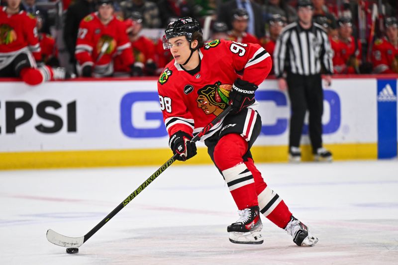 Dec 7, 2023; Chicago, Illinois, USA; Chicago Blackhawks forward Connor Bedard (98) skates the puck up ice during a power play in the first period against the Anaheim Ducks at United Center. Mandatory Credit: Jamie Sabau-USA TODAY Sports