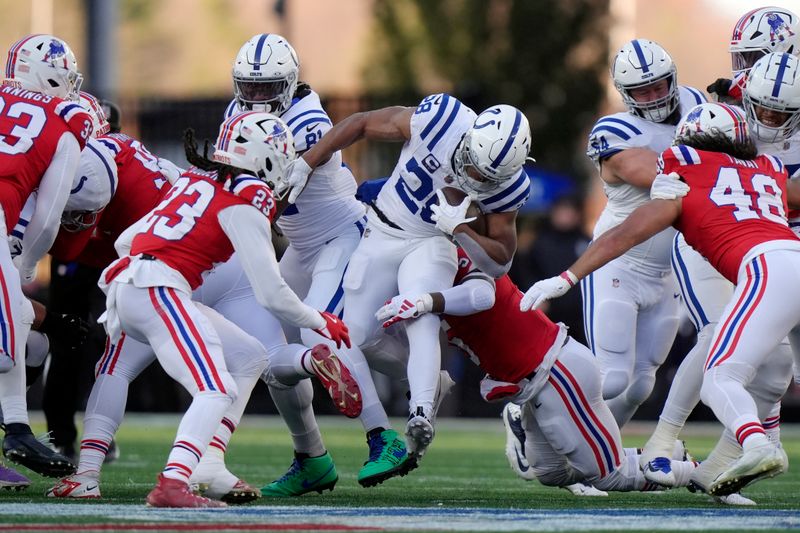 Indianapolis Colts running back Jonathan Taylor (28) carries the ball against New England Patriots safety Kyle Dugger (23) and linebacker Jahlani Tavai (48) during the second half of an NFL football game, Sunday, Dec. 1, 2024, in Foxborough, Mass. (AP Photo/Steven Senne)