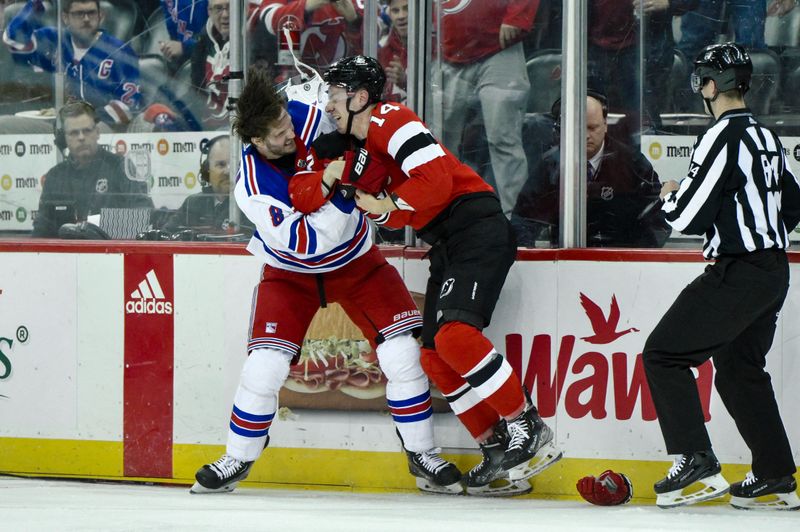 Feb 22, 2024; Newark, New Jersey, USA; New York Rangers defenseman Jacob Trouba (8) and New Jersey Devils right wing Nathan Bastian (14) fight during the second period at Prudential Center. Mandatory Credit: John Jones-USA TODAY Sports