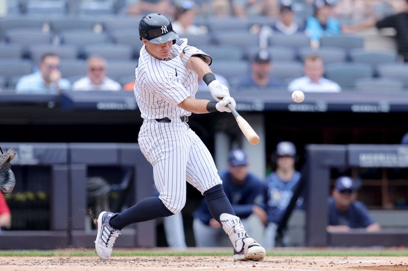 Jul 22, 2024; Bronx, New York, USA; New York Yankees shortstop Anthony Volpe (11) hits a solo home run against the Tampa Bay Rays during the second inning at Yankee Stadium. Mandatory Credit: Brad Penner-USA TODAY Sports