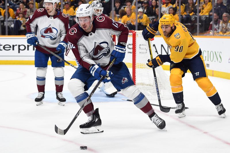 Mar 2, 2024; Nashville, Tennessee, USA; Colorado Avalanche center Ryan Johansen (12) gathers a loose puck during the third period against the Nashville Predators at Bridgestone Arena. Mandatory Credit: Christopher Hanewinckel-USA TODAY Sports