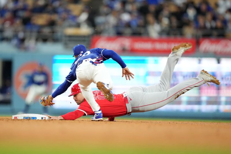 Mar 25, 2024; Los Angeles, California, USA; Los Angeles Angels first baseman Nolan Schanuel (18) slides into second base beneath the tag of Los Angeles Dodgers right fielder Mookie Betts (50) for a stolen base in the fourth inning at Dodger Stadium. Mandatory Credit: Kirby Lee-USA TODAY Sports