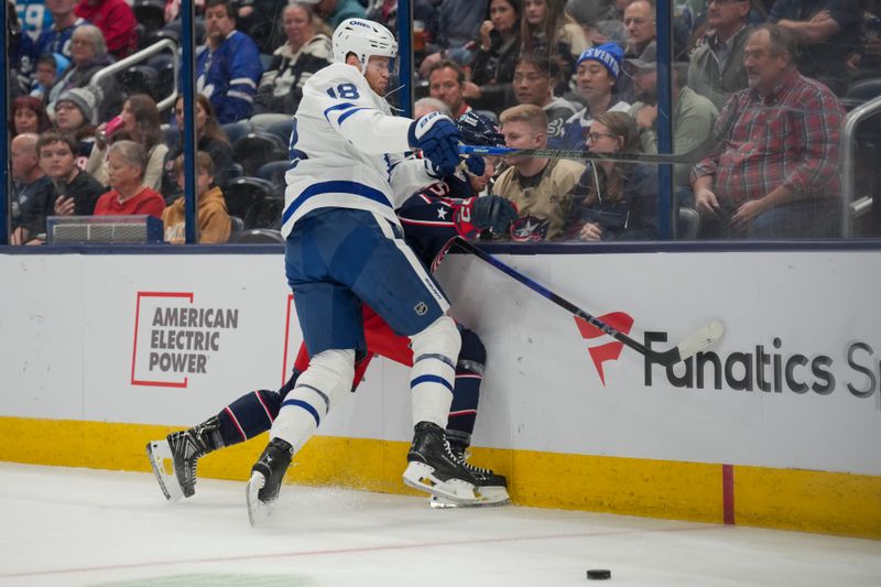 Oct 22, 2024; Columbus, Ohio, USA; Toronto Maple Leafs center Steven Lorentz (18) checks Columbus Blue Jackets defenseman David Jiricek (55) into the boards during the first period at Nationwide Arena. Mandatory Credit: Aaron Doster-Imagn Images