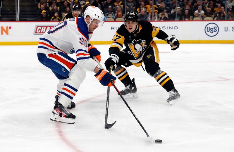 Mar 10, 2024; Pittsburgh, Pennsylvania, USA;  Edmonton Oilers right wing Corey Perry (90) moves the puck against Pittsburgh Penguins defenseman Ryan Graves (27) during the second period at PPG Paints Arena. The Oilers won 4-0. Mandatory Credit: Charles LeClaire-USA TODAY Sports