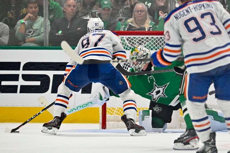 May 23, 2024; Dallas, Texas, USA; Dallas Stars goaltender Jake Oettinger (29) makes a stick save on Edmonton Oilers center Connor McDavid (97) during the overtime period in game one of the Western Conference Final of the 2024 Stanley Cup Playoffs at American Airlines Center. Mandatory Credit: Jerome Miron-USA TODAY Sports