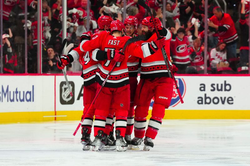 May 11, 2023; Raleigh, North Carolina, USA; Carolina Hurricanes center Jesperi Kotkaniemi (82) is congratulated by right wing Jesper Fast (71) defenseman Brent Burns (8) and defenseman Jaccob Slavin (74) after his goal against the New Jersey Devils during the second period in game five of the second round of the 2023 Stanley Cup Playoffs at PNC Arena. Mandatory Credit: James Guillory-USA TODAY Sports