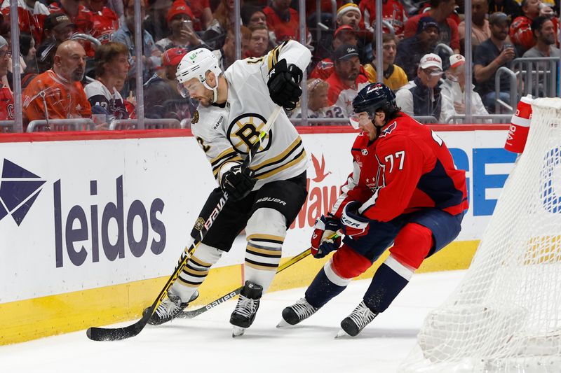 Apr 15, 2024; Washington, District of Columbia, USA; Boston Bruins defenseman Kevin Shattenkirk (12) skates with the puck as Washington Capitals right wing T.J. Oshie (77) defends in the third period at Capital One Arena. Mandatory Credit: Geoff Burke-USA TODAY Sports