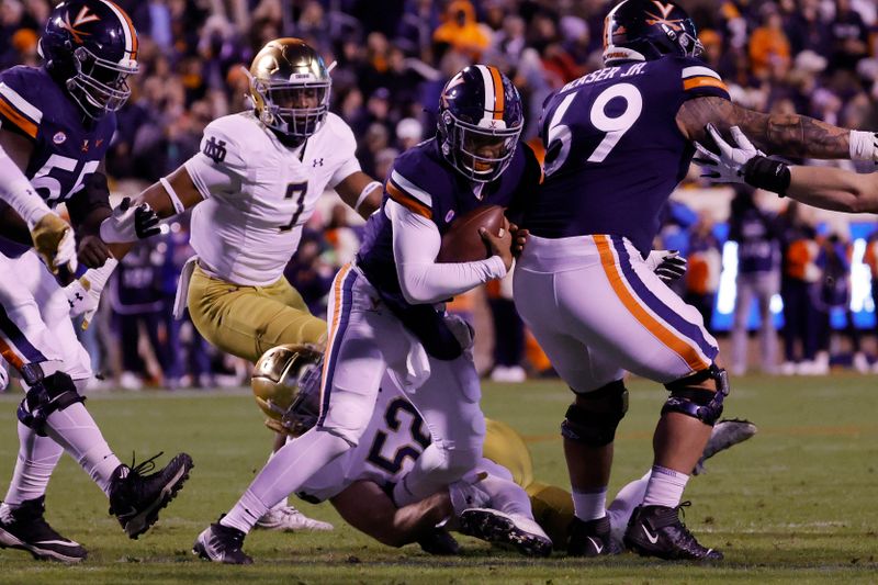 Nov 13, 2021; Charlottesville, Virginia, USA; Virginia Cavaliers quarterback Jay Woolfolk (16) is sacked by Notre Dame Fighting Irish linebacker Bo Bauer (52) during the first quarter at Scott Stadium. Mandatory Credit: Geoff Burke-USA TODAY Sportsa