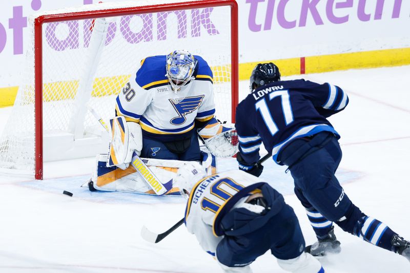 Dec 3, 2024; Winnipeg, Manitoba, CAN;  St. Louis Blues goalie Joel Hofer (30) makes a save on a shot by Winnipeg Jets forward Adam Lowry (17) during the third period at Canada Life Centre. Mandatory Credit: Terrence Lee-Imagn Images