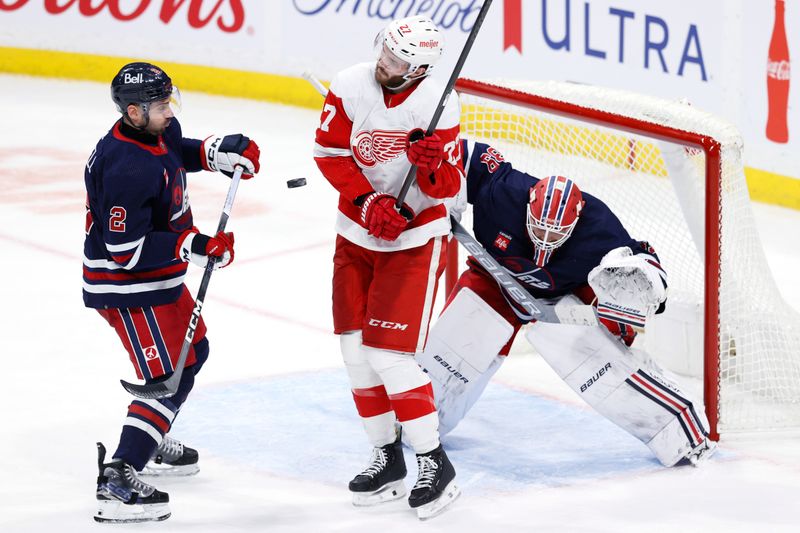 Dec 20, 2023; Winnipeg, Manitoba, CAN; Detroit Red Wings center Michael Rasmussen (27) dodges the puck while screening Winnipeg Jets goaltender Laurent Brossoit (39) in the third period at Canada Life Centre. Mandatory Credit: James Carey Lauder-USA TODAY Sports