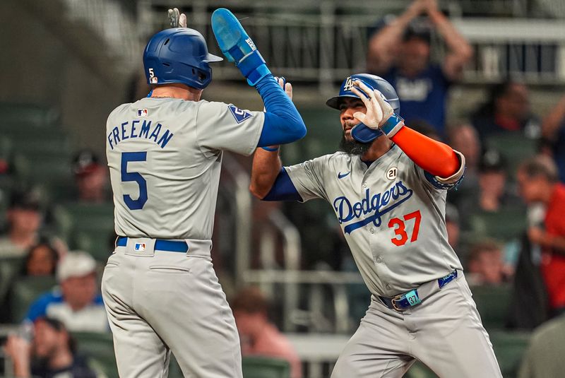 Sep 15, 2024; Cumberland, Georgia, USA; Los Angeles Dodgers left fielder Teoscar Hernandez (37) reacts with first baseman Freddie Freeman (5) after hitting a two run home run against the Atlanta Braves during the ninth inning at Truist Park. Mandatory Credit: Dale Zanine-Imagn Images