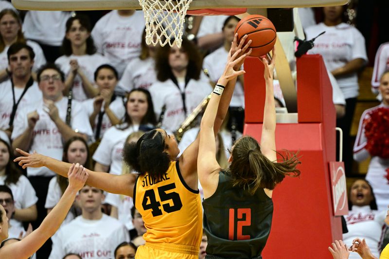 Feb 22, 2024; Bloomington, Indiana, USA; Iowa Hawkeyes forward Hannah Stuelke (45) blocks a shot by Indiana Hoosiers guard Yarden Garzon (12) during the first quarter at Simon Skjodt Assembly Hall. Mandatory Credit: Marc Lebryk-USA TODAY Sports