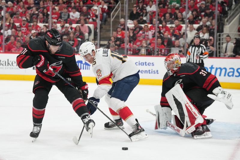 May 20, 2025; Raleigh, North Carolina, USA;  Carolina Hurricanes forward Taylor Hall (71) and goaltender Frederik Andersen (31) defend against Florida Panthers forward Anton Lundell (15) during the second period in game one of the Eastern Conference Final of the 2025 Stanley Cup Playoffs at Lenovo Center. Mandatory Credit: James Guillory-Imagn Images