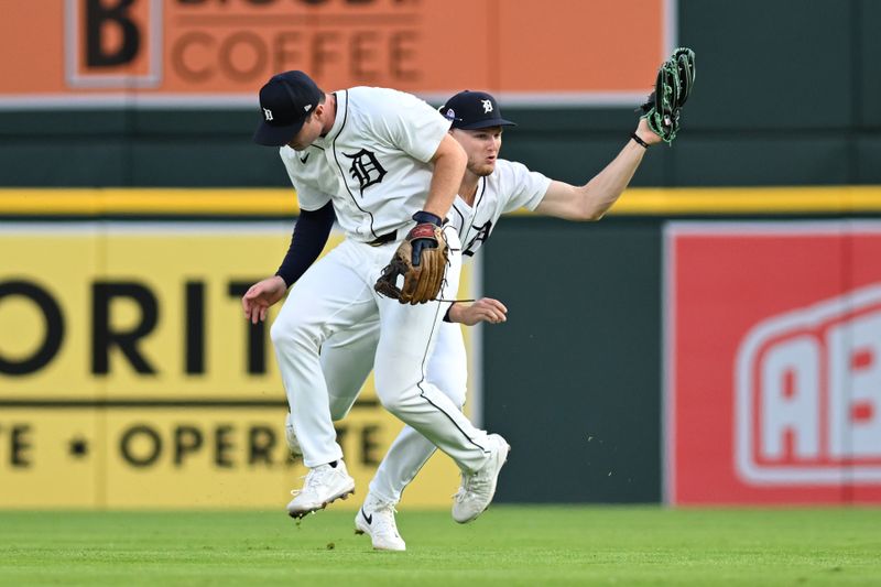 Sep 11, 2024; Detroit, Michigan, USA; Detroit Tigers second baseman Colt Keith (33) ducks out of the way of center fielder Parker Meadows (22) to avoid a collision as Meadows ran in to catch a shallow fly ball behind second base against the Colorado Rockies in the first inning at Comerica Park. Mandatory Credit: Lon Horwedel-Imagn Images