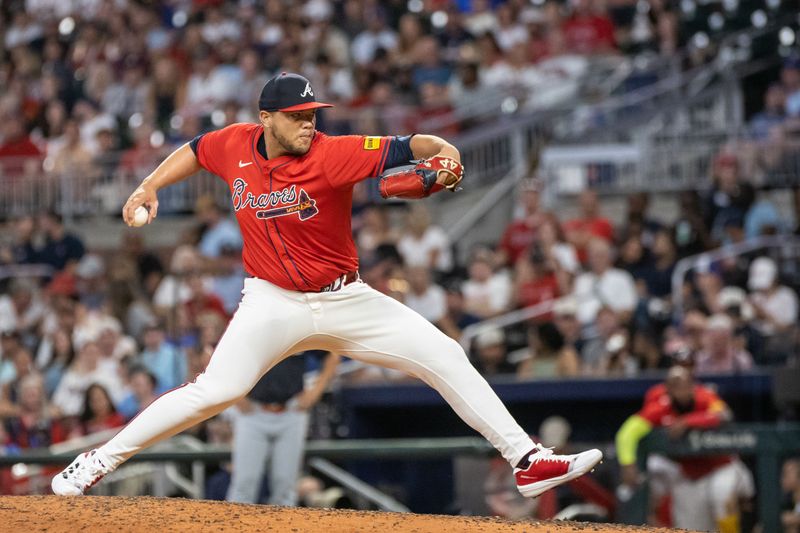 Aug 23, 2024; Cumberland, Georgia, USA; Atlanta Braves pitcher Joe Jiménez (77) pitches the ball against Washington Nationals during the eighth inning at Truist Park. Mandatory Credit: Jordan Godfree-USA TODAY Sports