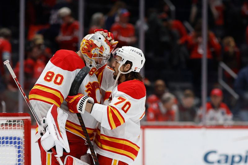 Feb 25, 2025; Washington, District of Columbia, USA; Calgary Flames goaltender Dan Vladar (80) celebrates with Flames left wing Ryan Lomberg (70) after their game against the Washington Capitals at Capital One Arena. Mandatory Credit: Geoff Burke-Imagn Images