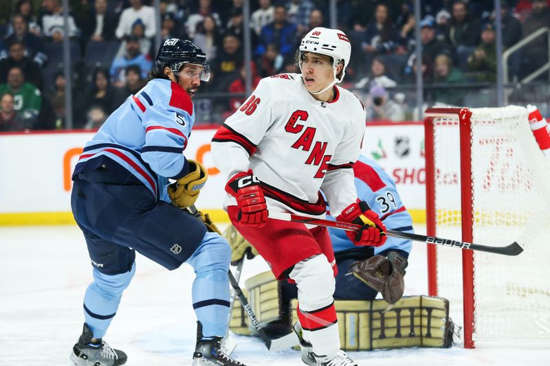 Dec 4, 2023; Winnipeg, Manitoba, CAN;   Winnipeg Jets defenseman Brenden Dillon (5) jostles for position with Carolina Hurricanes forward Teuvo Teravainen (86) during the first period at Canada Life Centre. Mandatory Credit: Terrence Lee-USA TODAY Sports