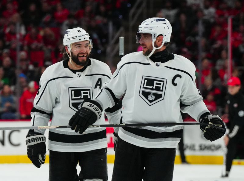 Jan 15, 2024; Raleigh, North Carolina, USA;  Los Angeles Kings center Anze Kopitar (11) and defenseman Drew Doughty (8) talk against the Carolina Hurricanes during the second period at PNC Arena. Mandatory Credit: James Guillory-USA TODAY Sports