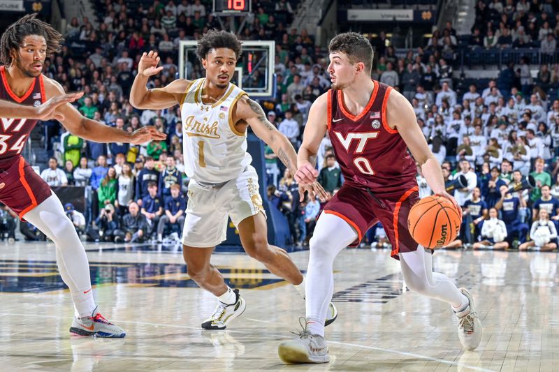 Feb 10, 2024; South Bend, Indiana, USA; Virginia Tech Hokies guard Hunter Cattoor (0) dribbles the ball against Notre Dame Fighting Irish guard Julian Roper II (1) in the first half at the Purcell Pavilion. Mandatory Credit: Matt Cashore-USA TODAY Sports