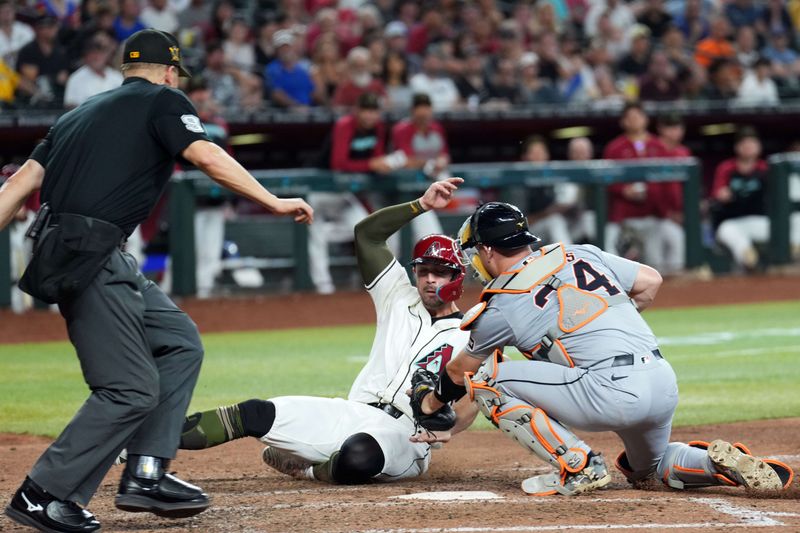 May 19, 2024; Phoenix, Arizona, USA; Arizona Diamondbacks catcher Tucker Barnhart (16) beats a throw to Detroit Tigers catcher Jake Rogers (34) to score a run during the seventh inning at Chase Field. Mandatory Credit: Joe Camporeale-USA TODAY Sports