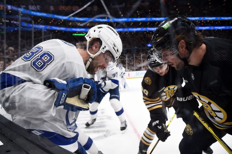 Feb 13, 2024; Boston, Massachusetts, USA;  Tampa Bay Lightning left wing Brandon Hagel (38) and Boston Bruins center Pavel Zacha (18) battle along the boards during the third period at TD Garden. Mandatory Credit: Bob DeChiara-USA TODAY Sports