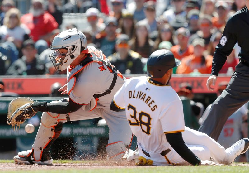 Apr 7, 2024; Pittsburgh, Pennsylvania, USA; Pittsburgh Pirates designated hitter Edward Olivares (right) slides home to score a run as Baltimore Orioles catcher James McCann (27) misses the catch during the fifth inning at PNC Park. Mandatory Credit: Charles LeClaire-USA TODAY Sports