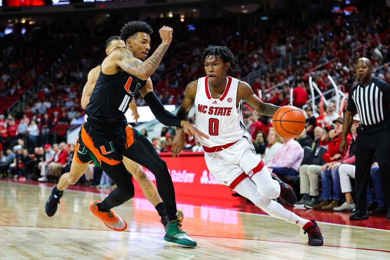 Jan 14, 2023; Raleigh, North Carolina, USA; North Carolina State Wolfpack guard Terquavion Smith (0) runs with the ball guarded by Miami Hurricanes guard Jordan Miller (11)  during the first half against Miami Hurricanes at PNC Arena. Mandatory Credit: Jaylynn Nash-USA TODAY Sports