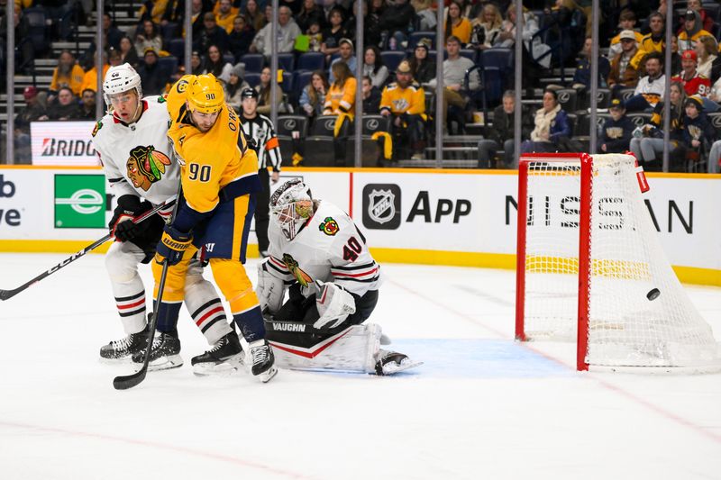 Jan 16, 2025; Nashville, Tennessee, USA;  Chicago Blackhawks goaltender Arvid Soderblom (40) blocks the shot of Nashville Predators center Ryan O'Reilly (90) during the third period at Bridgestone Arena. Mandatory Credit: Steve Roberts-Imagn Images