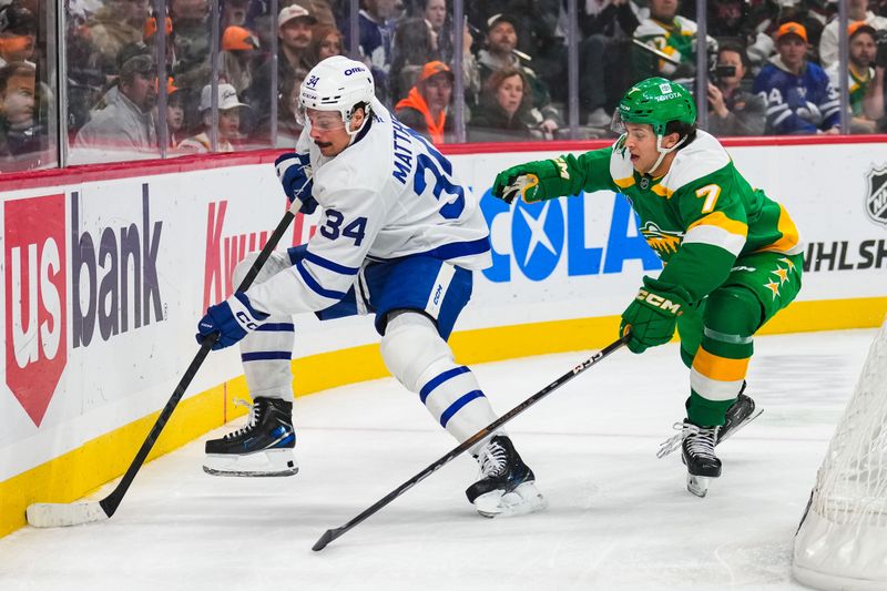 Nov 3, 2024; Saint Paul, Minnesota, USA; Toronto Maple Leafs center Auston Matthews (34) protects the puck from Minnesota Wild defenseman Brock Faber (7) during the first period at Xcel Energy Center. Mandatory Credit: Brace Hemmelgarn-Imagn Images