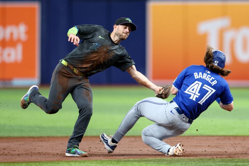 Sep 21, 2024; St. Petersburg, Florida, USA; Tampa Bay Rays second baseman Brandon Lowe (8) attempts to tag Toronto Blue Jays outfielder Addison Barger (47) in the first inning at Tropicana Field. Mandatory Credit: Nathan Ray Seebeck-Imagn Images