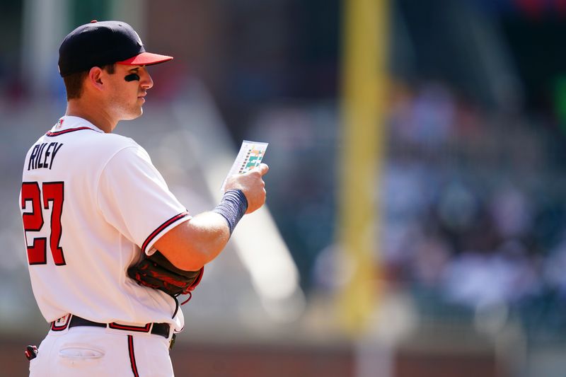 Sep 10, 2023; Cumberland, Georgia, USA; Atlanta Braves third baseman Austin Riley (27) looks over a scouting report for a Pittsburgh Pirates batter during the ninth inning at Truist Park. Mandatory Credit: John David Mercer-USA TODAY Sports